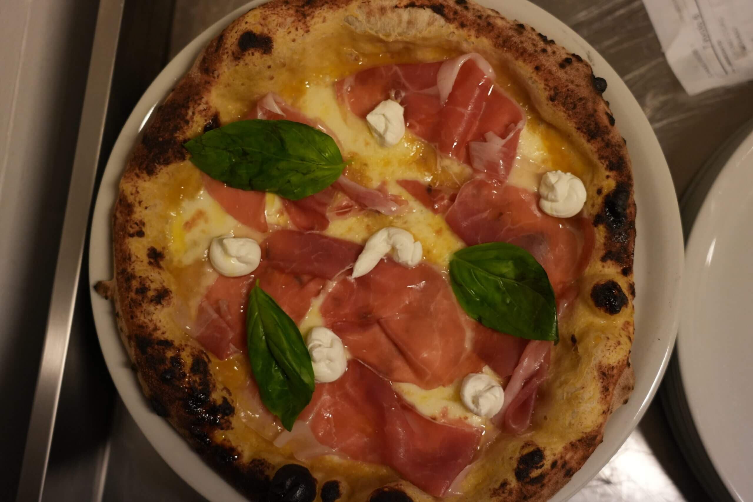 Pizza appena sfornata con condimenti vari
